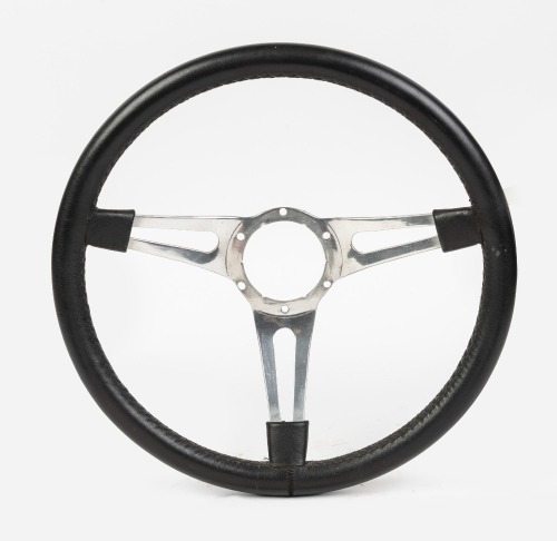 STEERING WHEEL: A three spoke leather rimmed steering wheel, US racing style, width 38cm