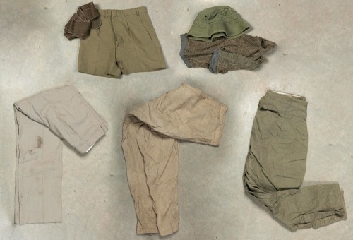 MILITARY UNIFORMS: A collection of vintage military clothing, including pants, shorts and a hat