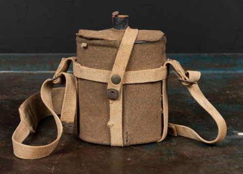 WWII: An Australian WWII blue enamel two pint water bottle with cork stopper, in wool felt cover and leather carrier, cork is slightly perished
