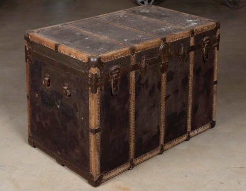 TRAVEL TRUNK: An antique iron and leather bound travelling trunk, 64cm high, 94cm wide, 58cm deep