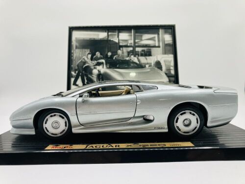 JAGUAR: A 1:18 scale model of the XJ220 by Maisto, mounted on plinth without original packaging together with a framed black and white photo of Kerry Manolas' XJ220 (K644 WJO) being unloaded, 33cm x 26cm