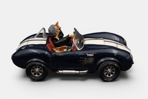 A limited edition (No.85071) resin sculpture by Guillermo Forchino titled 'Shelby Cobra 427 S/C' featuring a cool dude driving his Cobra, measures approximately 31cm in length, 16cm width, in as-new condition, within box
