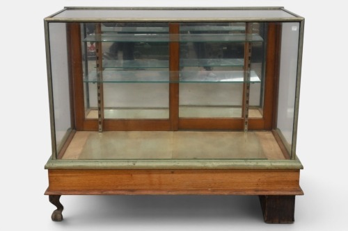 DISPLAY CABINET: An early 20th century display cabinet, with metal claw feet, one detached but present