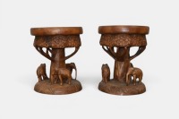 SIDE TABLES: Two solid timber carved side tables/stools featuring elephants, 48cm high, 39cm diameter