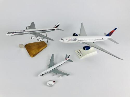 DELTA: 4 models (longest 33cm): A 1:200 scale Boeing 777-200LR resin model on stand, A 1:400 scale Boeing 747-400 metal model on wheels, registration 'N9896', A 1:200 scale McDonnell Douglas DC8 wooden model on stand and one Delta plastic toy plane on pul