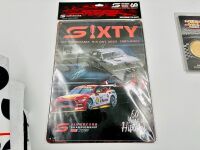 BATHURST: A large group of Bathurst memorabilia including a flag from the 2024 race, a commemorative coin celebrating 50 years of the Bathurst 1000. a 60th anniversary tin sign and a group of race programmes and stickers [Location: Sydney] - 2