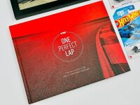 MAD MIKE WHIDDETT: A hardcover book, 'One Perfect Lap: The Wild History of the World Time Attack Challenge, together with 3 Hot Wheels models including one signed by Mad Mike and a framed photo of Mad Mike's Mazda 3 [Location: Sydney] - 3