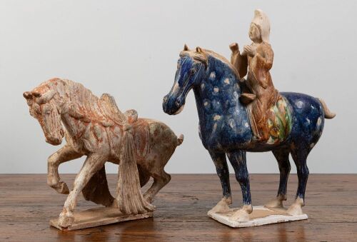 TANG: Two terracotta Tang style horse figures, one with overglaze in blue and rider, largest 39cm high, 38cm wide