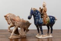 TANG: Two terracotta Tang style horse figures, one with overglaze in blue and rider, largest 39cm high, 38cm wide