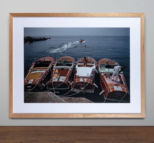 SLIM AARONS: A large photograph by Slim Aarons of four Riva boats moored in the picturesque French Riviera in the early 1960s, image 59cm high, 82cm wide