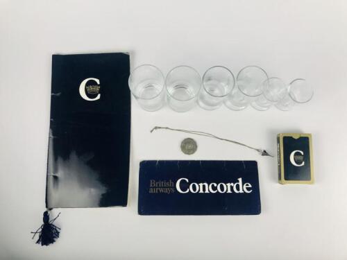 CONCORDE ITEMS: 5 items: A Concorde shaped necklace ornament on chain (possibly silver). A set of Concorde playing cards. A Concorde ticket wallet with two baggage tags. A concorde Menu Circa 1970's and A set of 6 Concorde glasses.