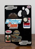CHRONOSPORT: A circa 1970s timing clip board with affixed American racing stickers and Junghans (Germany) 1/10 Second Stopwatch