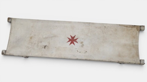 STRETCHER: A vintage military timber and canvas stretcher on wheels with pull out timber handles