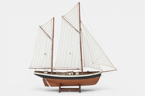 MODEL YACHT: A wooden model pond yacht in early 20th Century style on stand, 76cm long, 80cm high