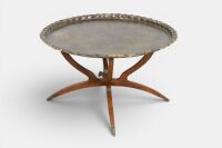 COFFEE TABLE: A large Middle Eastern style brass tray form coffee table on timber base, featuring a lion in foliage, diameter 77cm, 44cm high