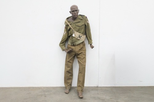 AUSTRALIAN ARMY: A circa 1950s Royal Australian Artillery woolen khaki battle dress jacket and pants, with belt, and a cross-body bag with mannequin