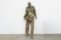 AUSTRALIAN ARMY: A circa 1950s Royal Australian Artillery woolen khaki battle dress jacket and pants, with belt, and a cross-body bag with mannequin