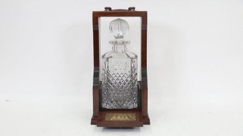 TANTALUS: A cut crystal decanter in timber tantalus, 30cm high