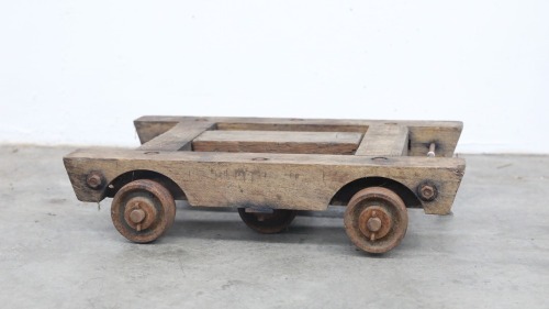 MOVING DOLLY: A c1920s or 1930s timber and steel moving dolly, 56cm long, 43cm wide