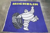 MICHELIN: A large circa 1980s fabric Michelin flag featuring waving Bibendum, 240cm high, 235cm wide