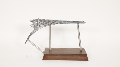 PEUGEOT: A Peugeot 203 roaring lion hood ornament, mounted to a timber base, suitable for desk or shelf display, measures 16cm high, 26cm wide overall