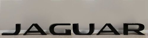 126 · JAGUAR: A Jaguar 1990s/2000s showroom display lettering sign in ebonised timber, aprox 450cm wide, 39cm high, 15cm deep