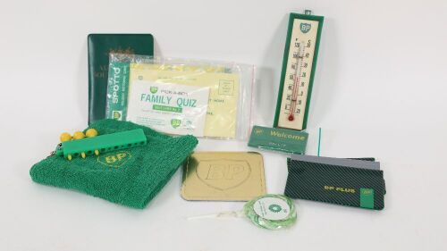BP: A group of BP promotional items, including a small plastic thermometer, a coaster, a BP employee name tag and other items