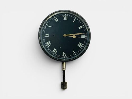 CLOCK: A vintage clock with white markings on black face and Roman numerals