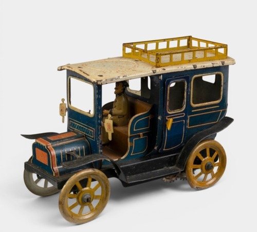 LIMOUSINE: A circa 1900s German clockwork tin toy limousine with driver, 18cm long