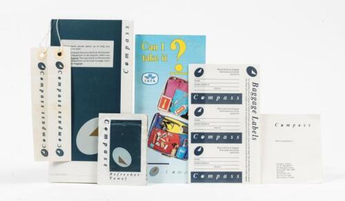COMPASS AIRLINES: A c2000s small ticketing folder contening various Compass items including, a with compliment slip, baggage label stickers, cabin luggage string tags and a refresher towel.