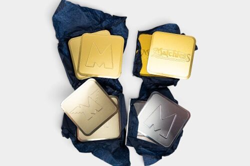MATCHLESS: A set of four Matchless branded drink coasters, three in gold tone and one in silver [Location: Melbourne]