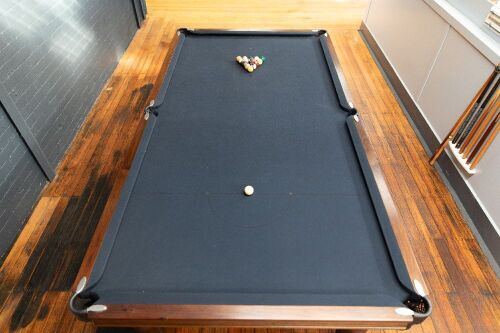 POOL TABLE: A pool / billiard table complete with triangles, pool balls, billiard balls, scoreboard, overhead lamp, cues & cue rack and table cover, thought to a nine foot tournament sized table