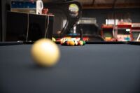 POOL TABLE: A pool / billiard table complete with triangles, pool balls, billiard balls, scoreboard, overhead lamp, cues & cue rack and table cover, thought to a nine foot tournament sized table - 4