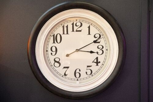 CLOCK: A large timber wall clock, 77cm wide