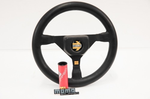 MOMO: A small Momo three spoke, leather steering wheel with Momo labelled perspex holder, wheel 27cm wide [Location: Melbourne]