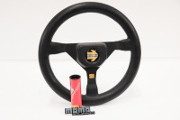 MOMO: A small Momo three spoke, leather steering wheel with Momo labelled perspex holder, wheel 27cm wide [Location: Melbourne]