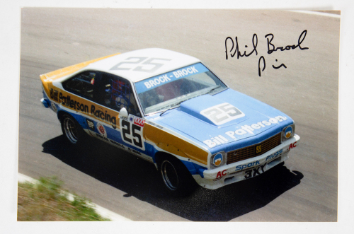 BROCK BROTHERS: A signed photograph featuring the 1977 'Brock Brothers' Holden Torana A9X racing at Bathurst, signed by Phil Brock, 20cm high, 30cm wide