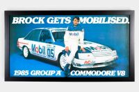 BROCK: An original advertising poster 'Brock Gets Mobilised, 1985 Group A Commodore V8', framed and glazed, measures 43.5cm high, 79cm wide