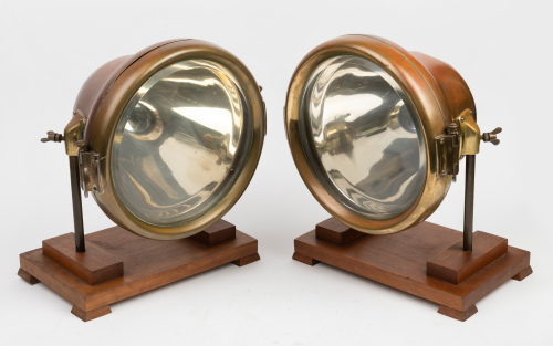 HEADLAMPS: A pair of large brass headlamps, lens width 23cm (9 inches), mounting bracket width 20cm, both mounted to timber bases