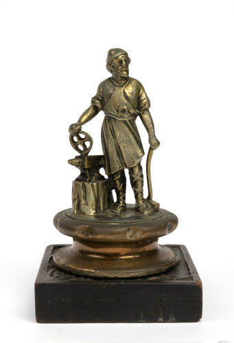 VULCAN: A c1920 Vulcan 'Blacksmith' bronze mascot, mascot 15cm high, mounted on timber base, cap width 9cm