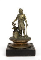 VULCAN: A c1920 Vulcan 'Blacksmith' bronze mascot, mascot 15cm high, mounted on timber base, cap width 9cm [Location: Melbourne]