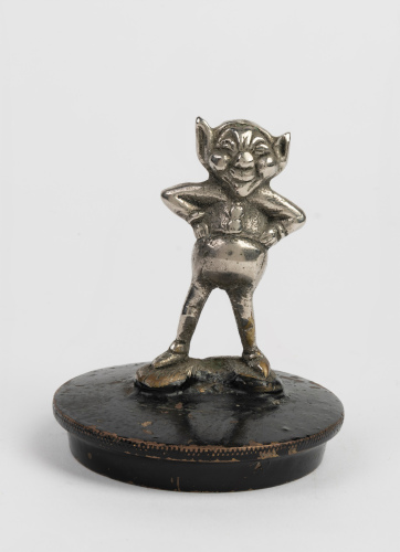 MASCOT: A c1920 British 'Cheeky Imp' car mascot affixed to cap, overall height 9cm, width 7.5cm