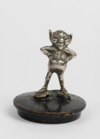 MASCOT: A c1920 British 'Cheeky Imp' car mascot affixed to cap, overall height 9cm, width 7.5cm [Location: Melbourne]