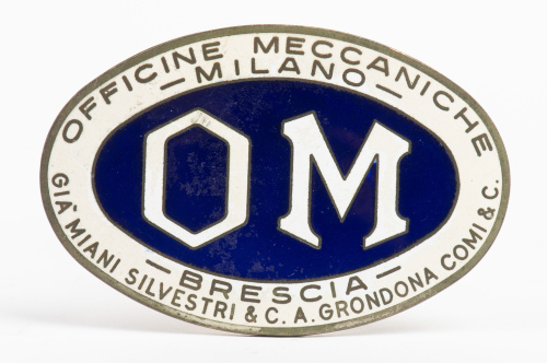 OFFICINE MECCANICHE: An oval 'Officine Meccaniche - Milano - Brescia' badge, blue enamel centre, 9.5cm wide