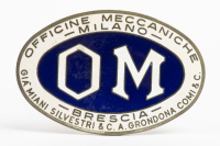 OFFICINE MECCANICHE: An oval 'Officine Meccaniche - Milano - Brescia' badge, blue enamel centre, 9.5cm wide [Location: Melbourne]