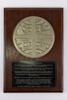 GPDA: A Grand Prix Drivers Association plaque, believed to be one of four produced in the 1960s, mounted on timber [Location: Perth]