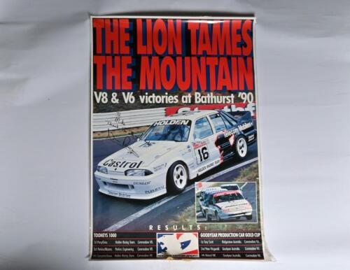 COMMODORE V8: A large Holden Motor Sport poster - 'THE LION TAMES THE MOUNTAIN' - depicting Win Percy/Alan Grice driving a Holden Commodore V8 to victory at Bathurst 1990. Poster signed by Win Percy (140cm high x 97cm wide)