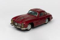 MERCEDES: A 1950s Japanese friction operated tin toy of a Mercedes Benz Gullwing 300 SL 2-door coupe by Bandai