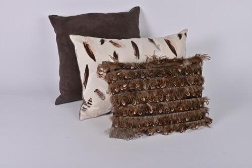 CUSHIONS: Three brown tone cushions including a guinea fowl feather decorated cashion, 40 x 25cm
