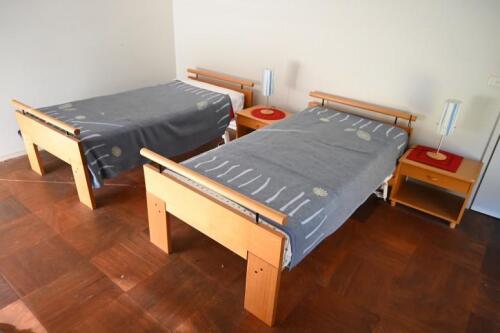 BEDROOM FURNITURE: A pair of single beds and a pair of bedside tables designed by Peter Sands, Victoria *(see note)